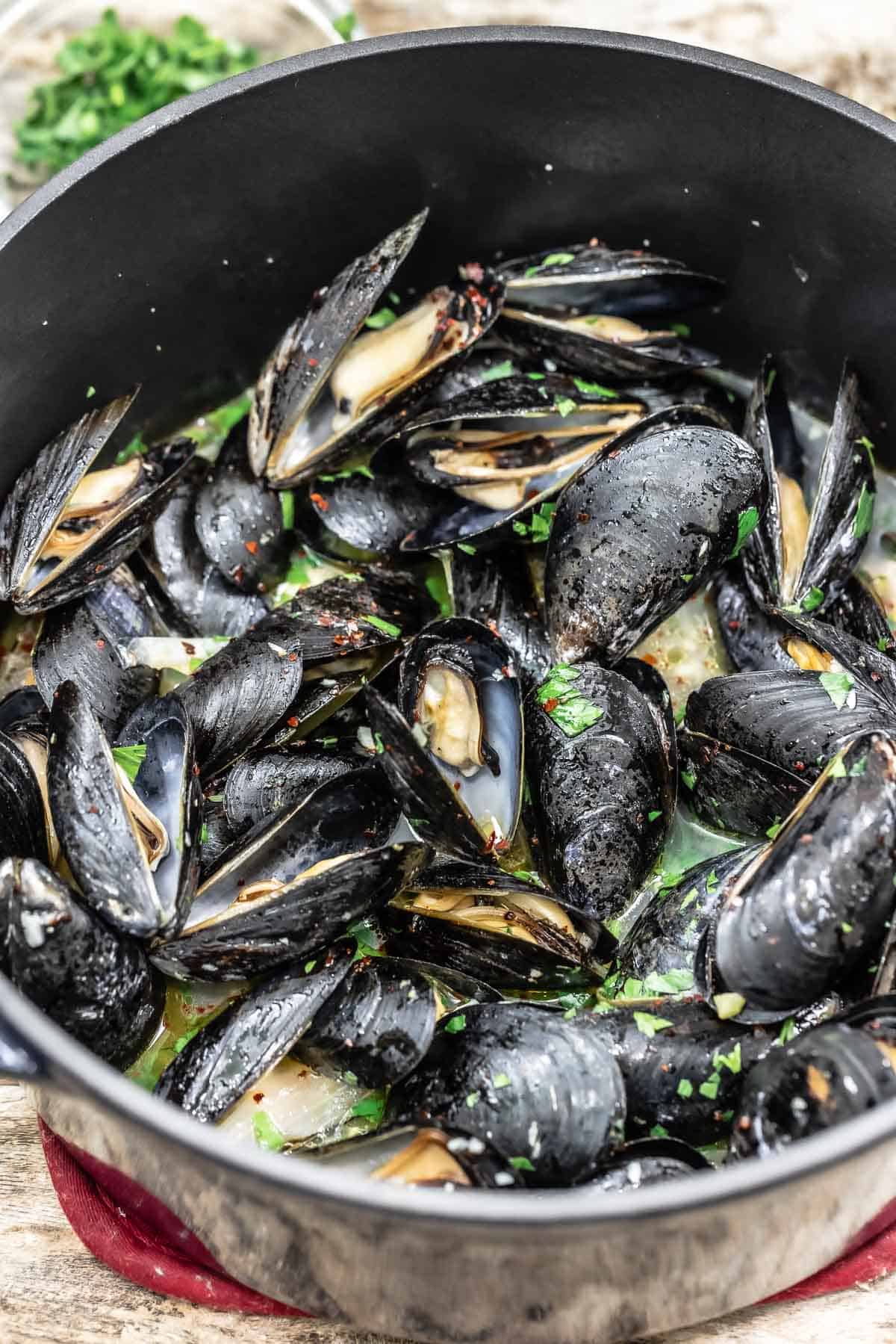 Mussels in a dutch oven with parsley.