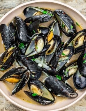 Steamed mussels with a garlicky broth in a small bowl.