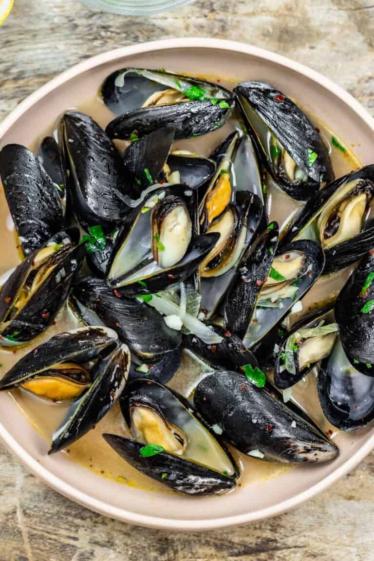 Steamed mussels with a garlicky broth in a small bowl.