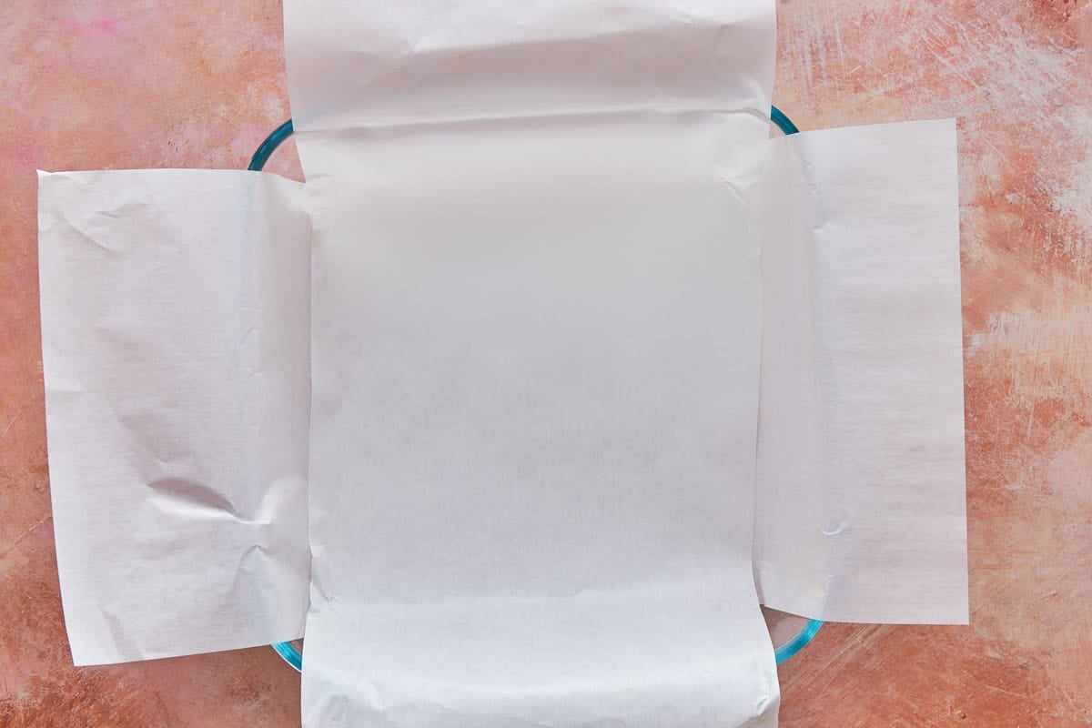 a square glass baking dish lined with parchment paper.