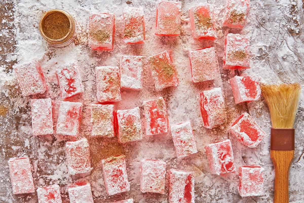 pieces of turkish delight being dusted with gold edible glitter.