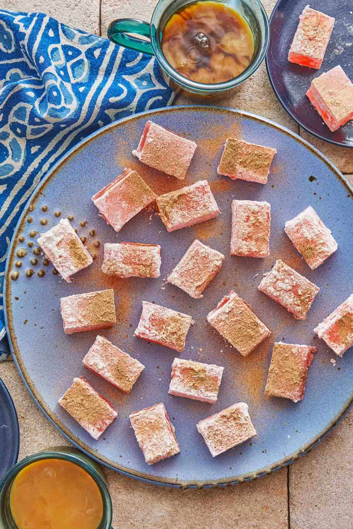 pieces of turkish delight (lokum) on a serving platter with a cup of coffee.