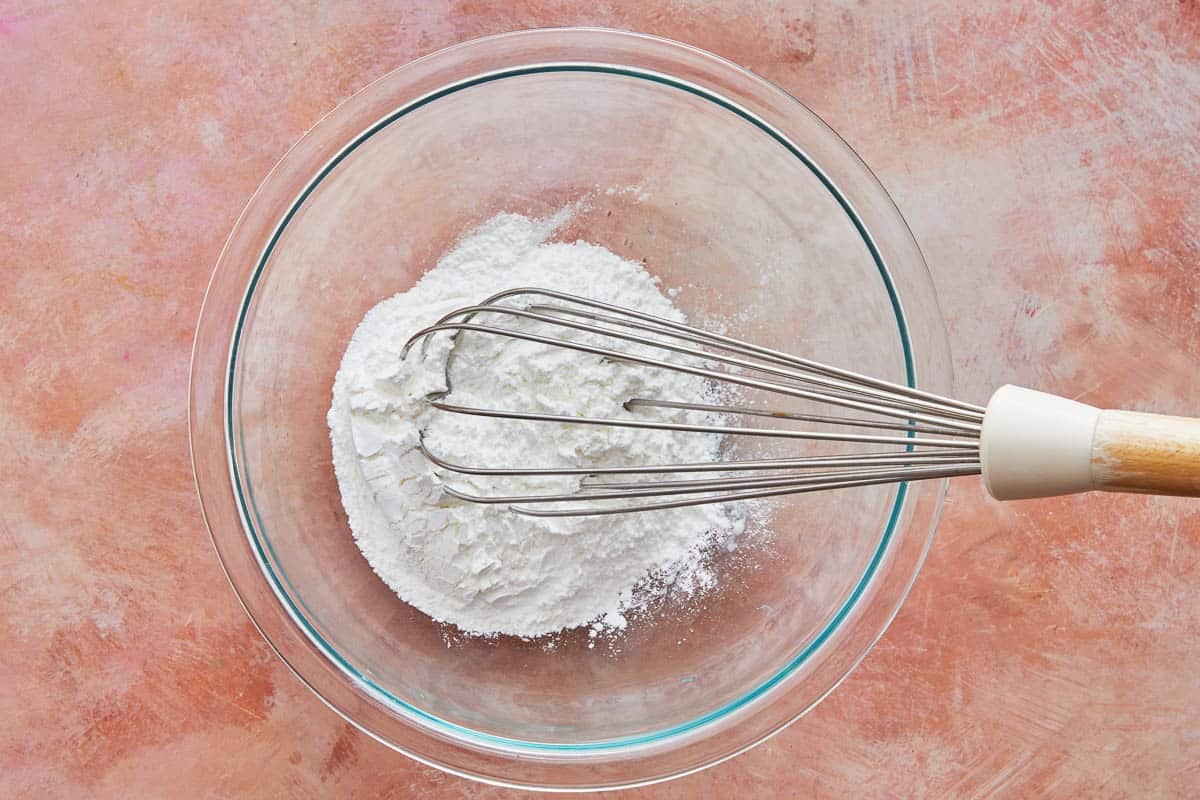 cornstarch and powdered sugar being whisked in a bowl.
