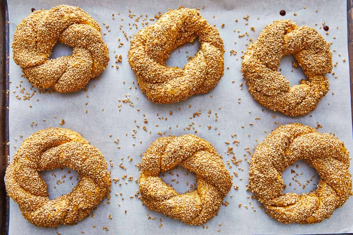 six simit dough rings on parchment paper.