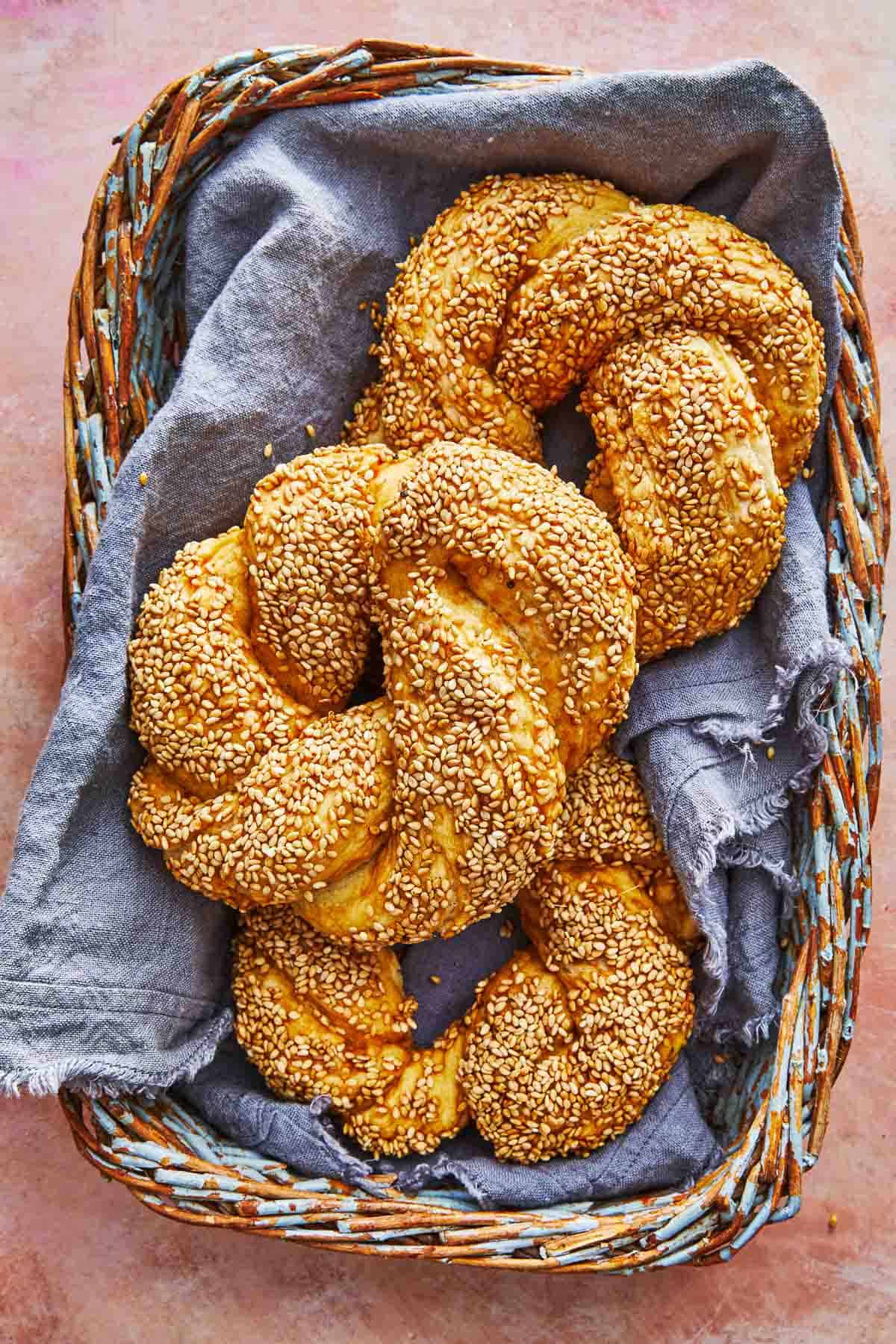 three baked simit dough rings in a basket.