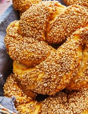 a close up of a baked simit dough ring in a basket.