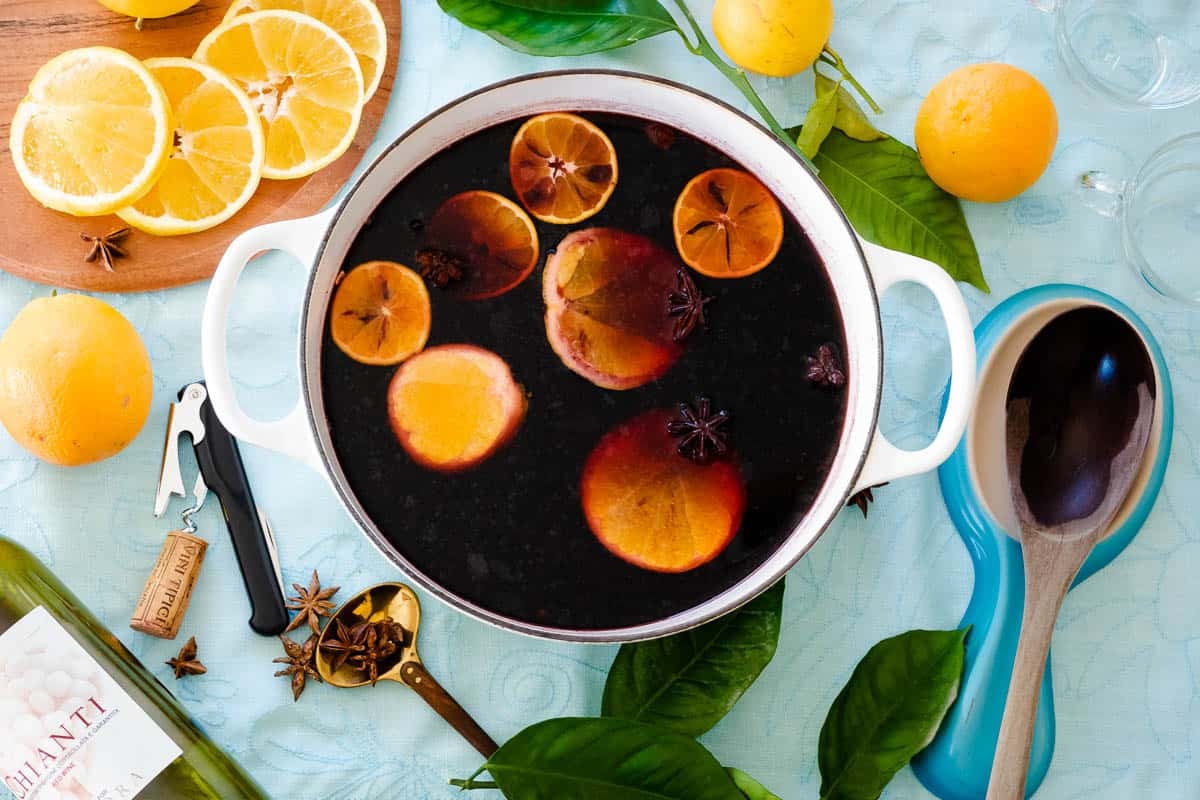 wine, liqueur, orange peels, honey and spices simmering in a dutch oven.