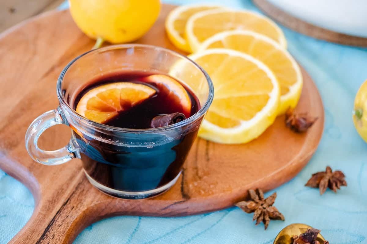 one cup of mulled wine with orange slices and a cinnamon stick.