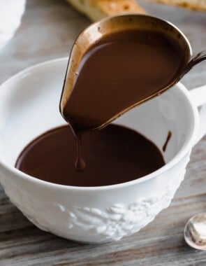 italian hot chocolate (Cioccolato Caldo) being poured into a tea cup with a ladle.