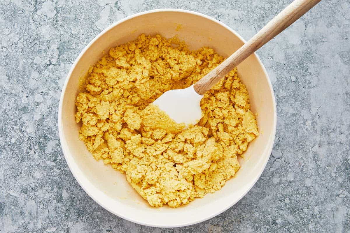 dough for ma'amoul in a bowl being stirred with a spatula.