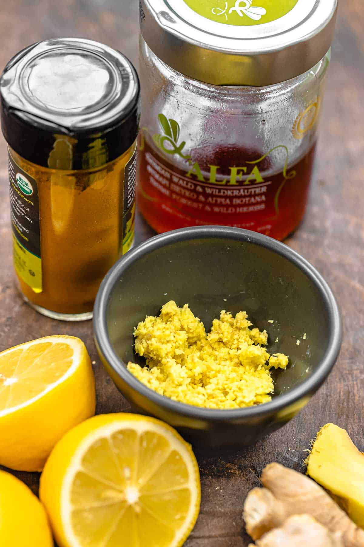 ingredients for ginger tea including ginger, lemon, turmeric, and honey.