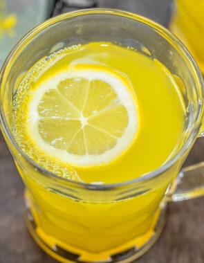 close up of ginger tea with a slice of lemon in a glass mug.