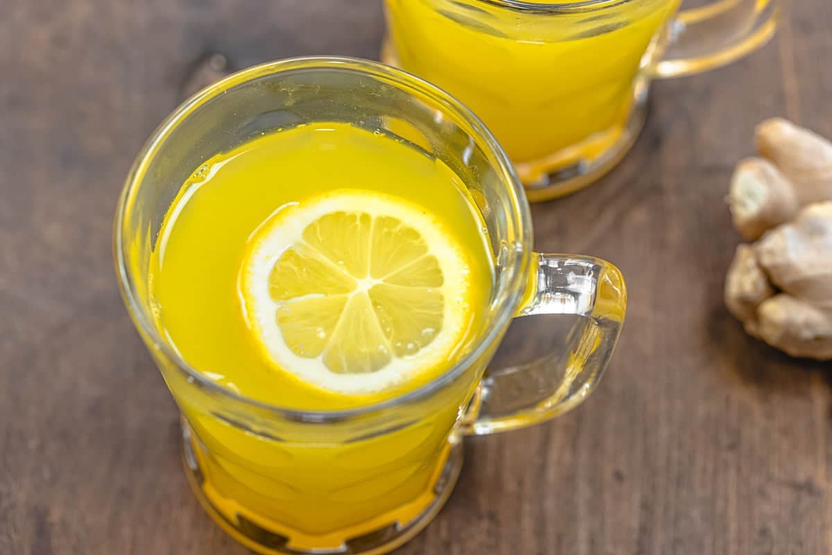 ginger tea with a slice of lemon in a glass mug.