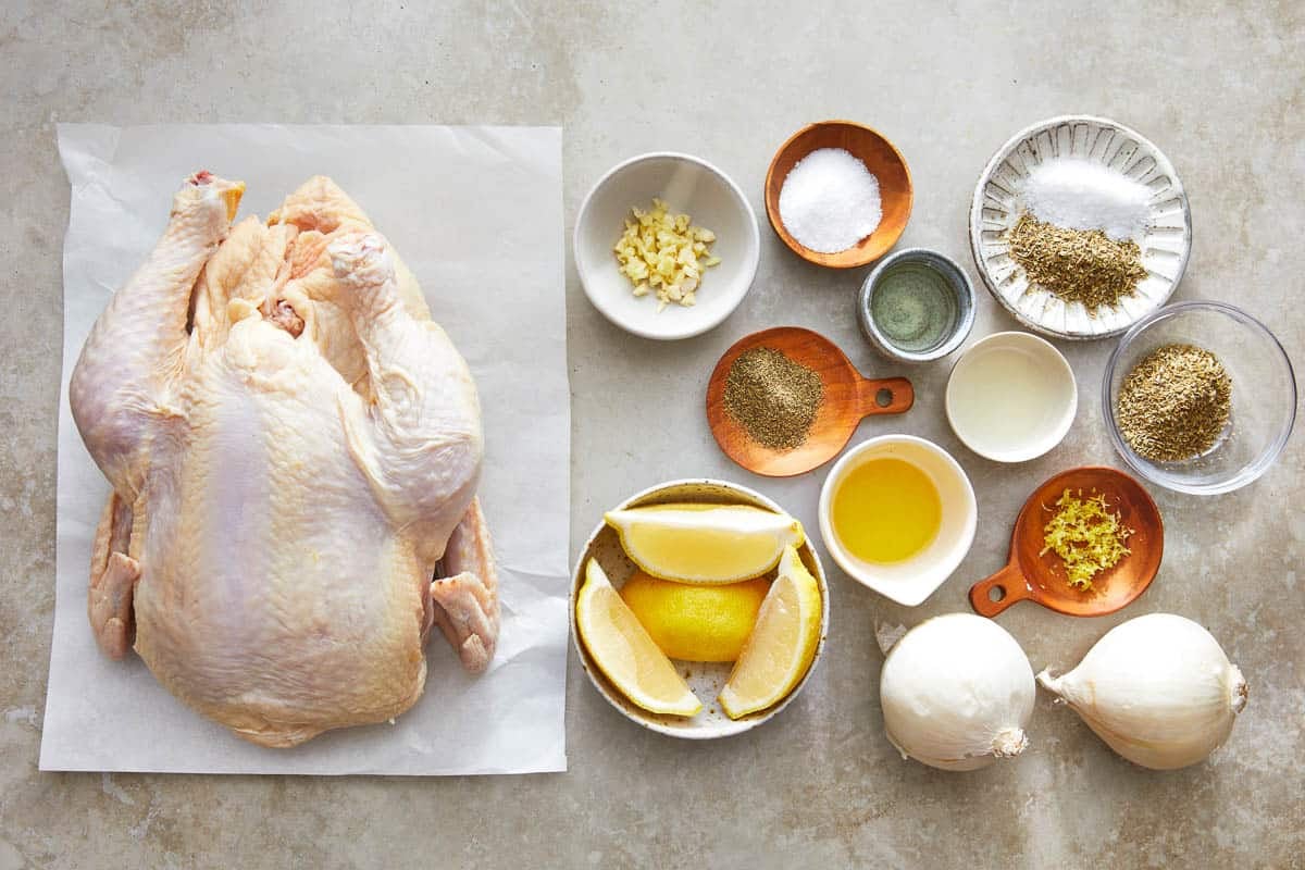 ingredients for roasted whole chicken included a chicken, garlic, lemon, onions, olive oil and spices.