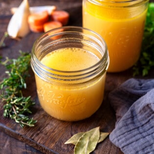 cooked chicken stock in two glass jars.