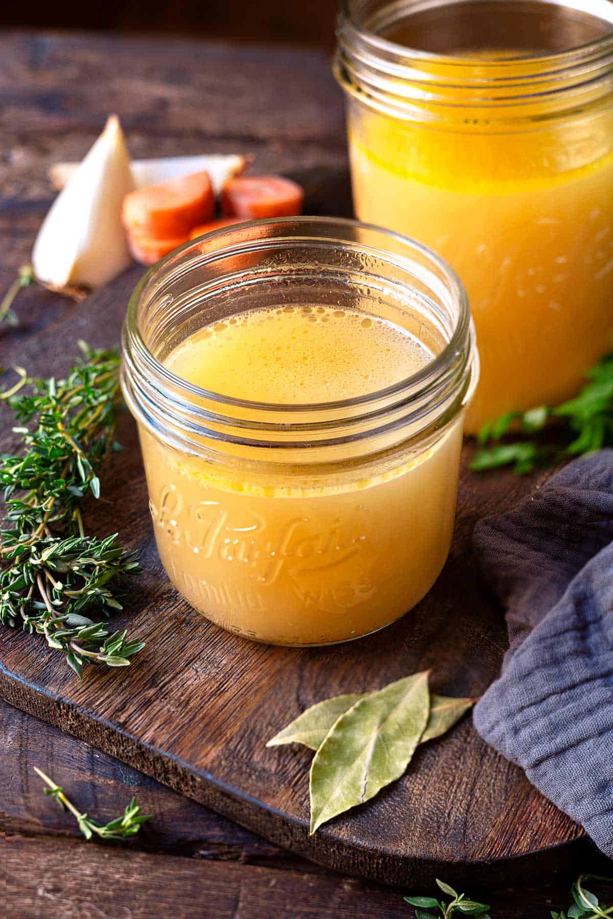 cooked chicken stock in two glass jars.