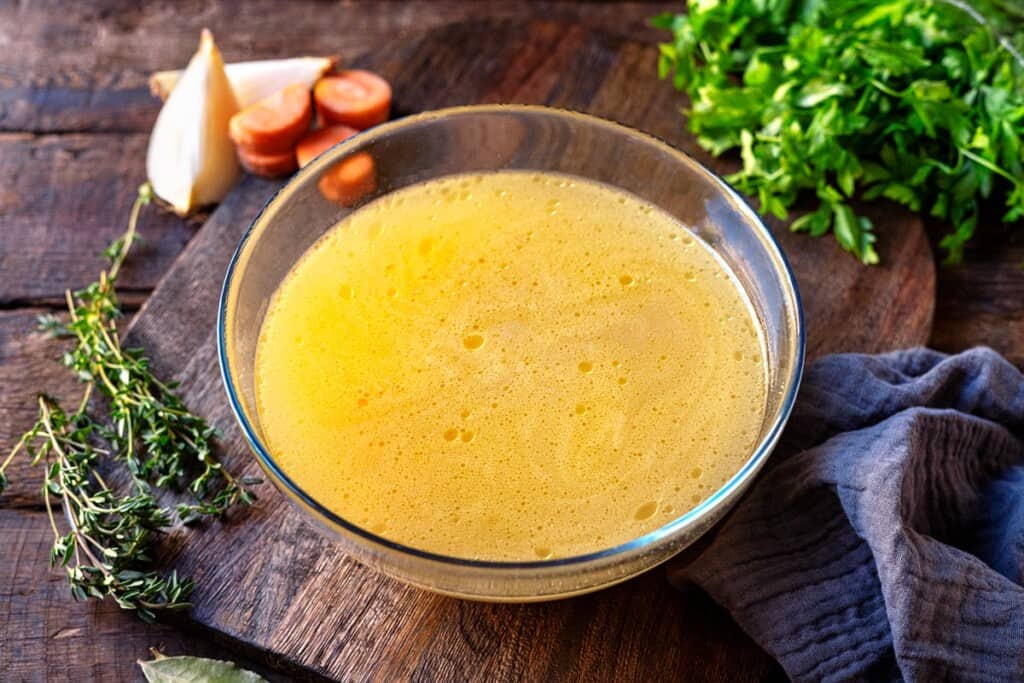 cooked chicken stock in a glass bowl.