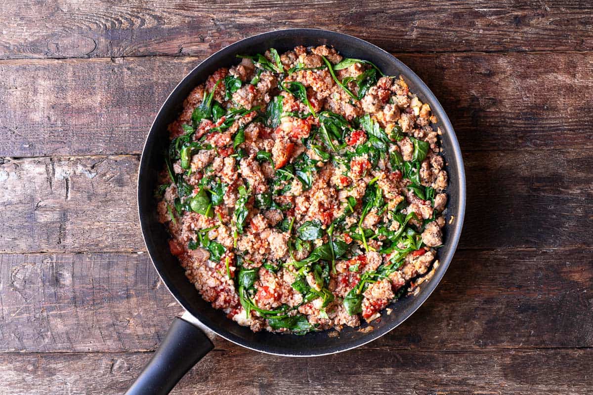 meat filling for italian stuffed peppers cooking in a skillet.