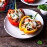 two cooked stuffed pepper halves on a plate.