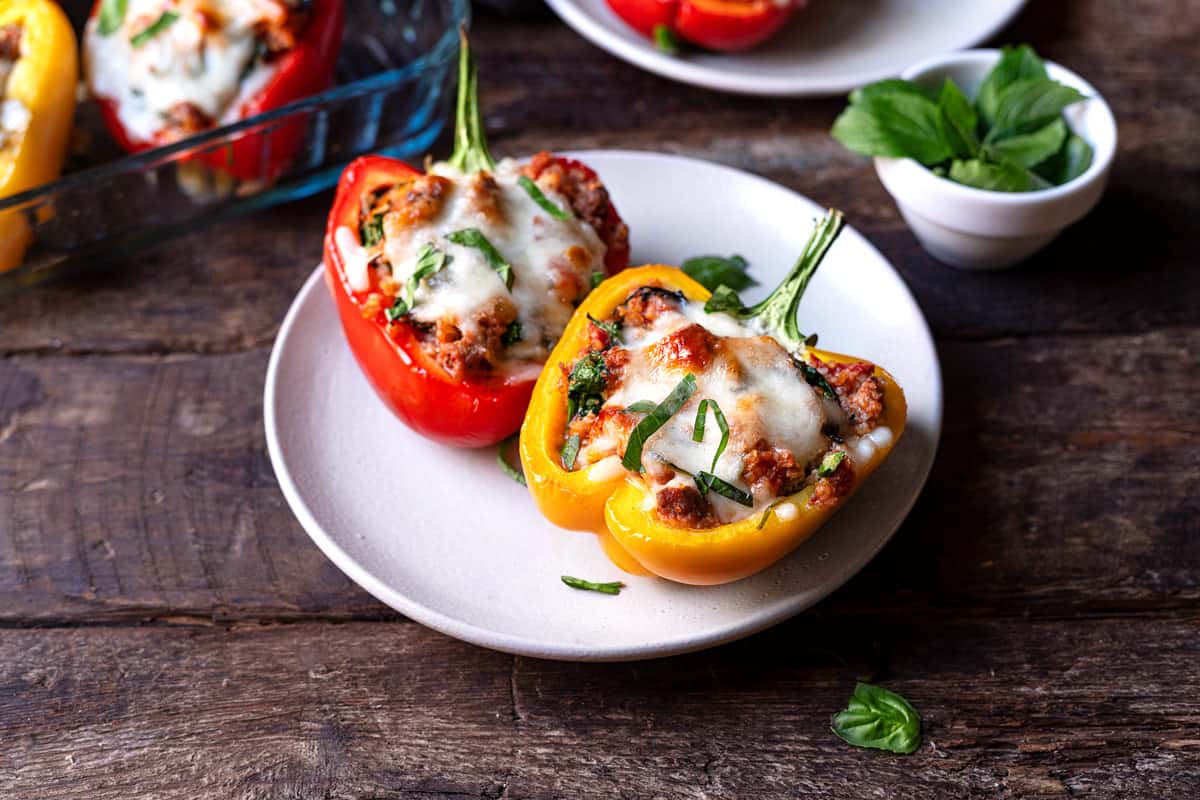 two cooked stuffed pepper halves on a plate.