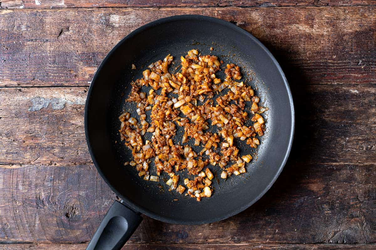 onions and garlic sautéing in a skillet.