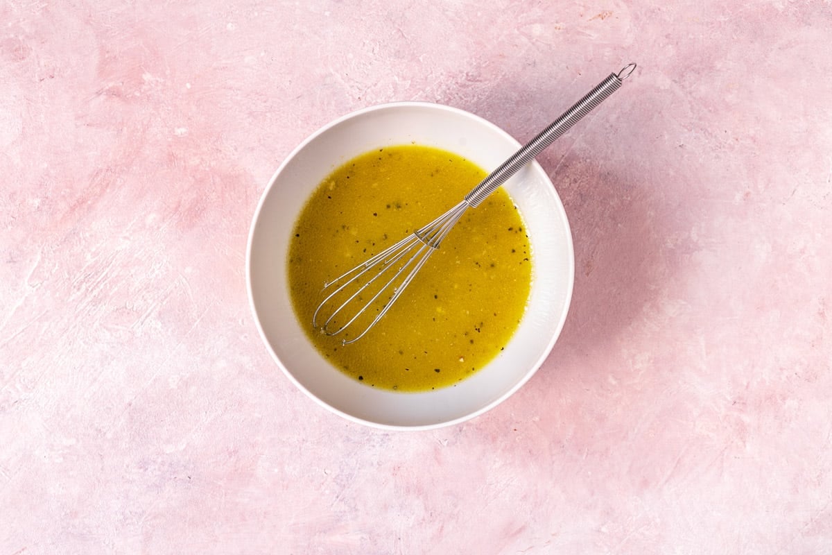 apple cider vinaigrette in a bowl with a wisk.