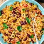 spanish rice and beans on a plate with a fork.