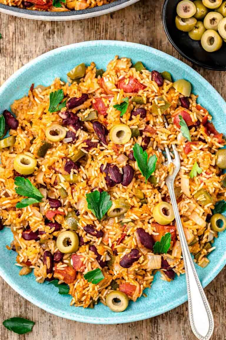 spanish rice and beans on a plate with a fork.
