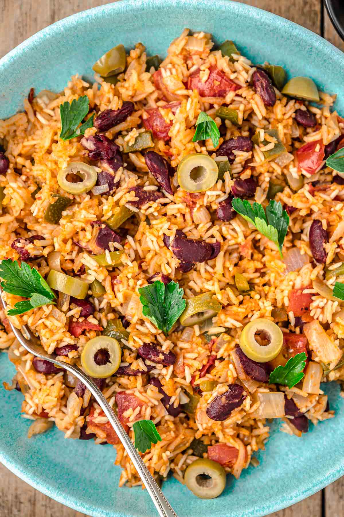 spanish rice and beans on a plate with a fork.