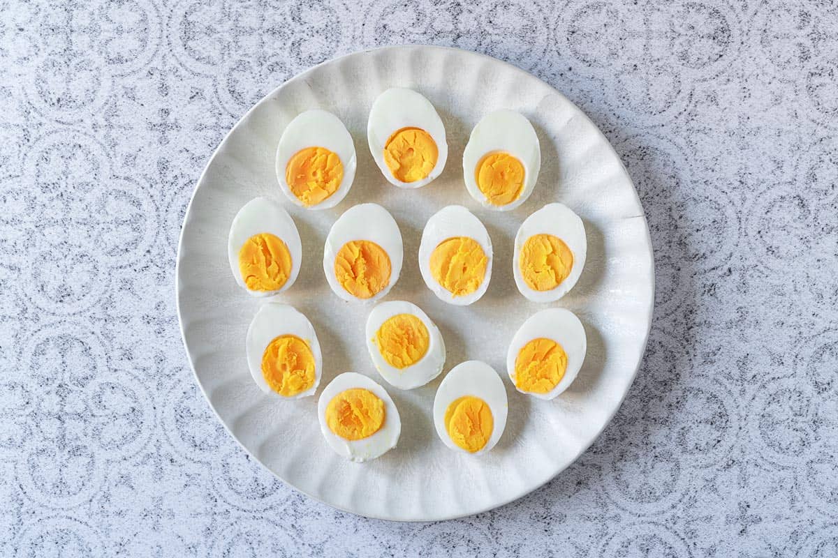 12 hard boiled egg halves on a plate.