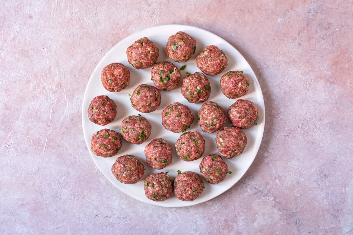 uncooked meatballs on a plate.