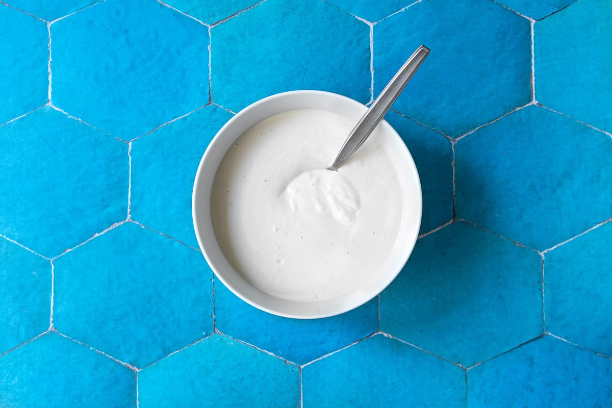 garlicky yogurt in a bowl with a spoon.