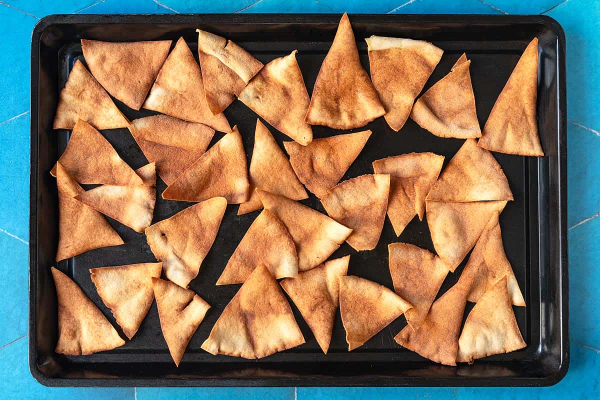 toasted pita triangles on a baking sheet.