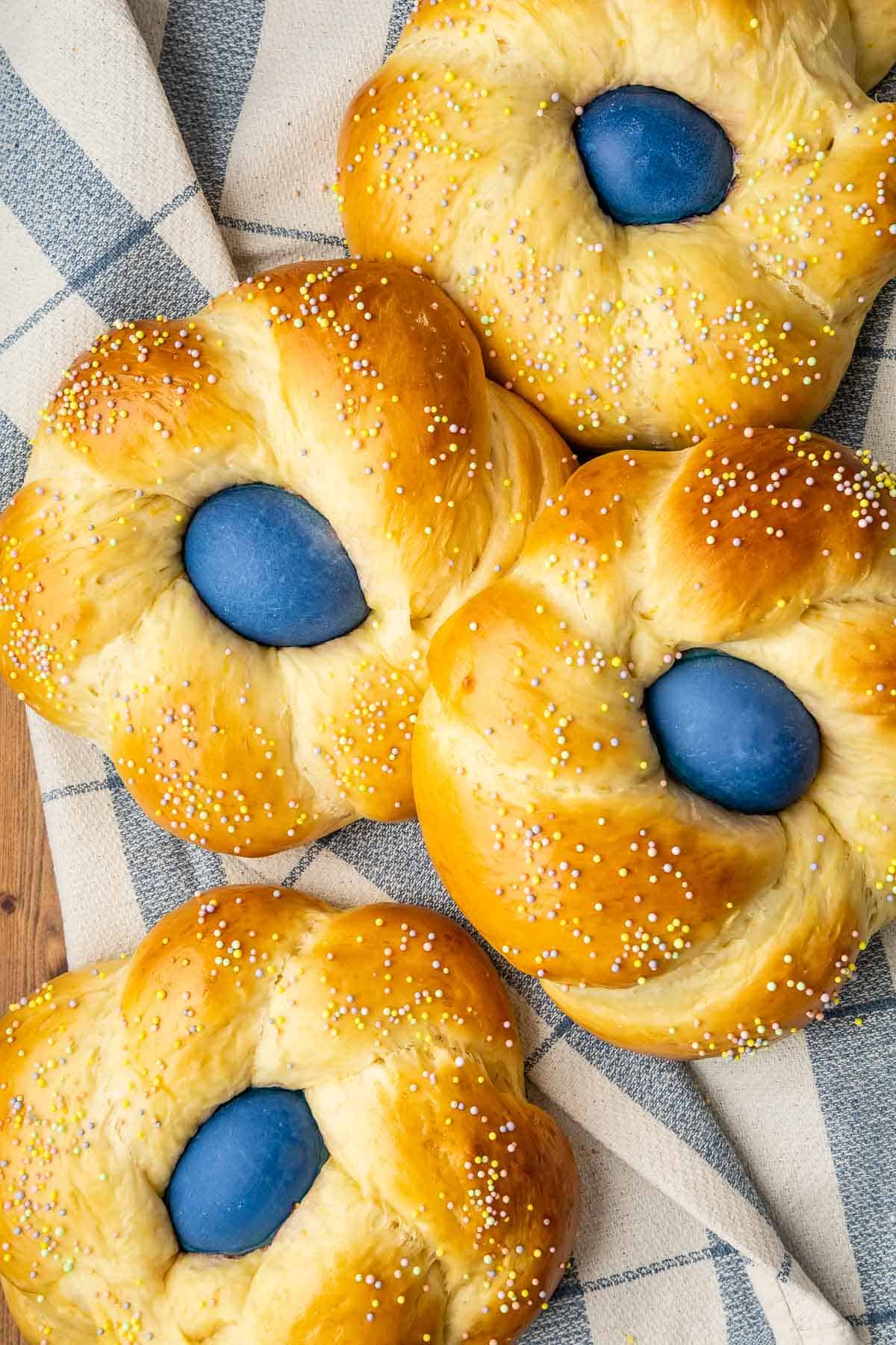 four italian easter breads on a cloth napkin.