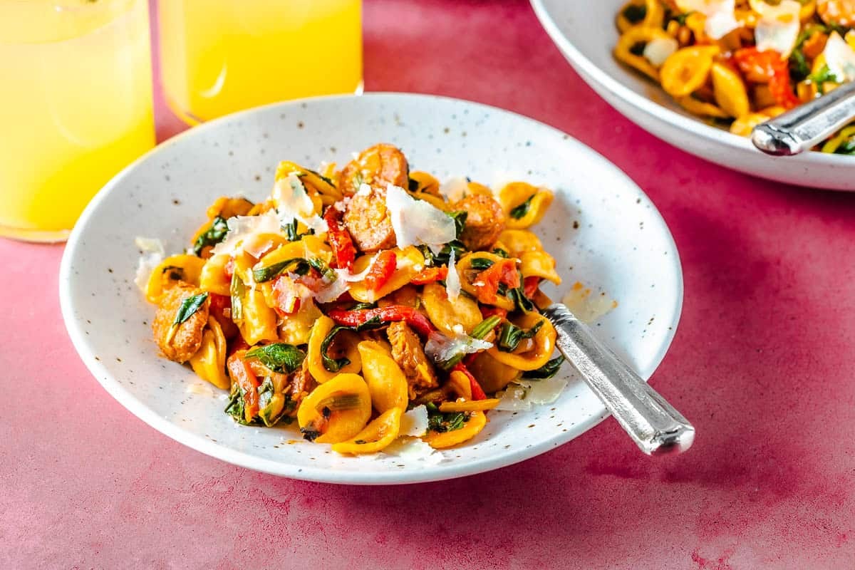 Bowl of chorizo pasta with manchego cheese and roasted red peppers.