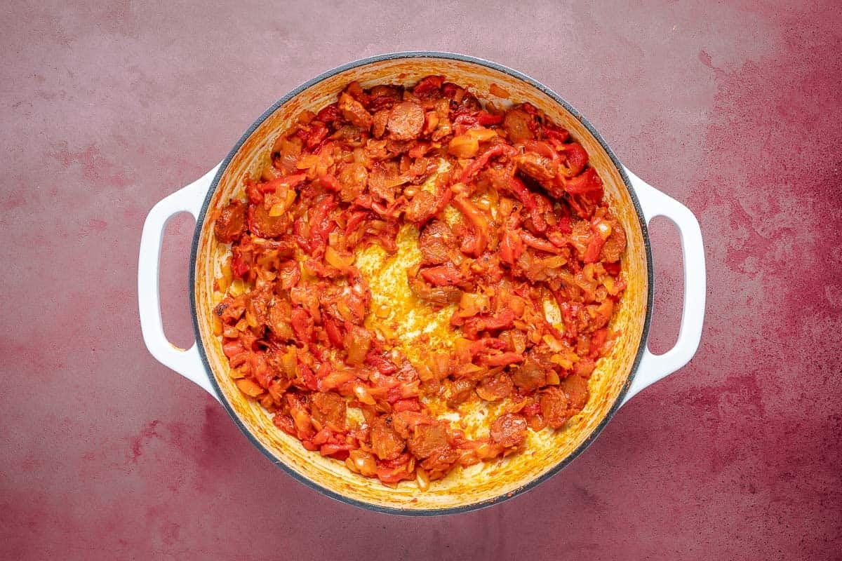 Dutch oven with spicy Spanish chorizo, red peppers, and tomato paste.