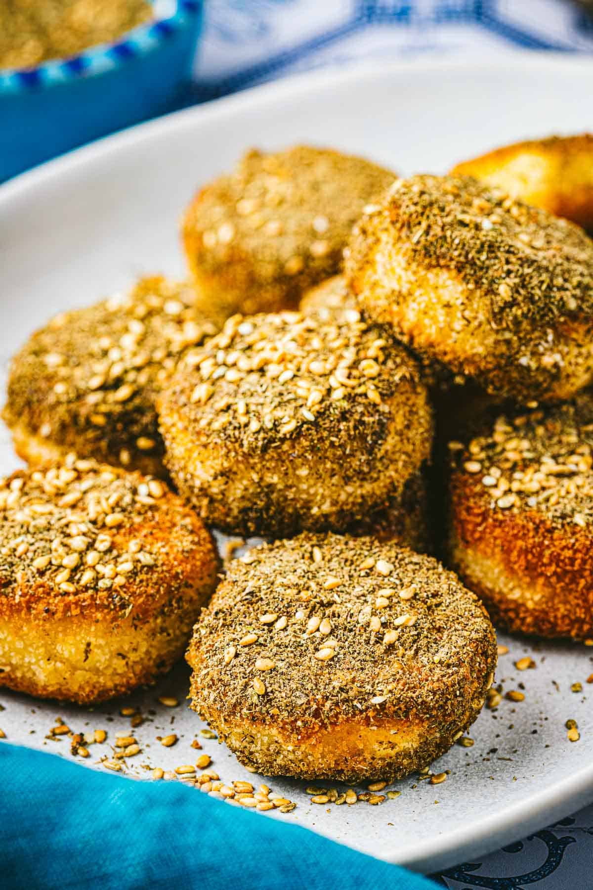 close up of a stack of fried goat cheese slices on a plate.