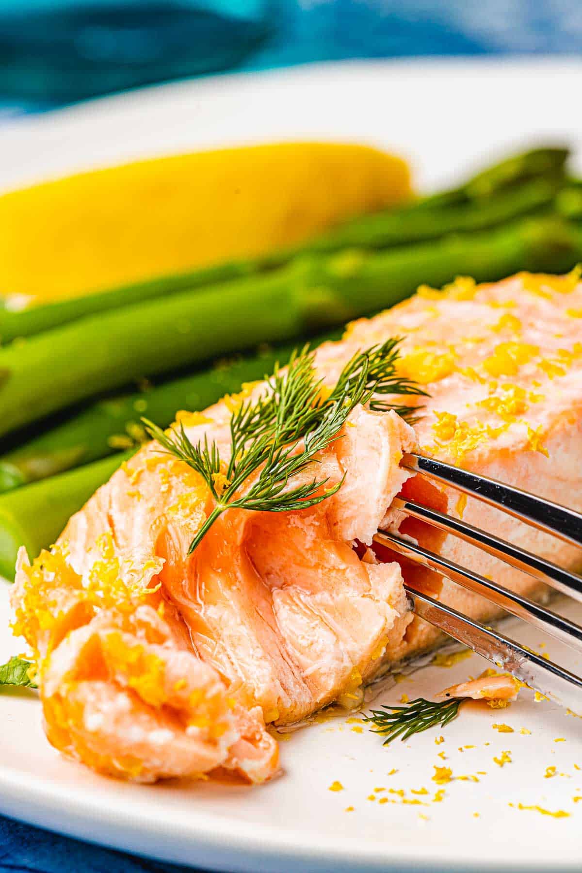 a fork cutting in a a poached salmon fillet.