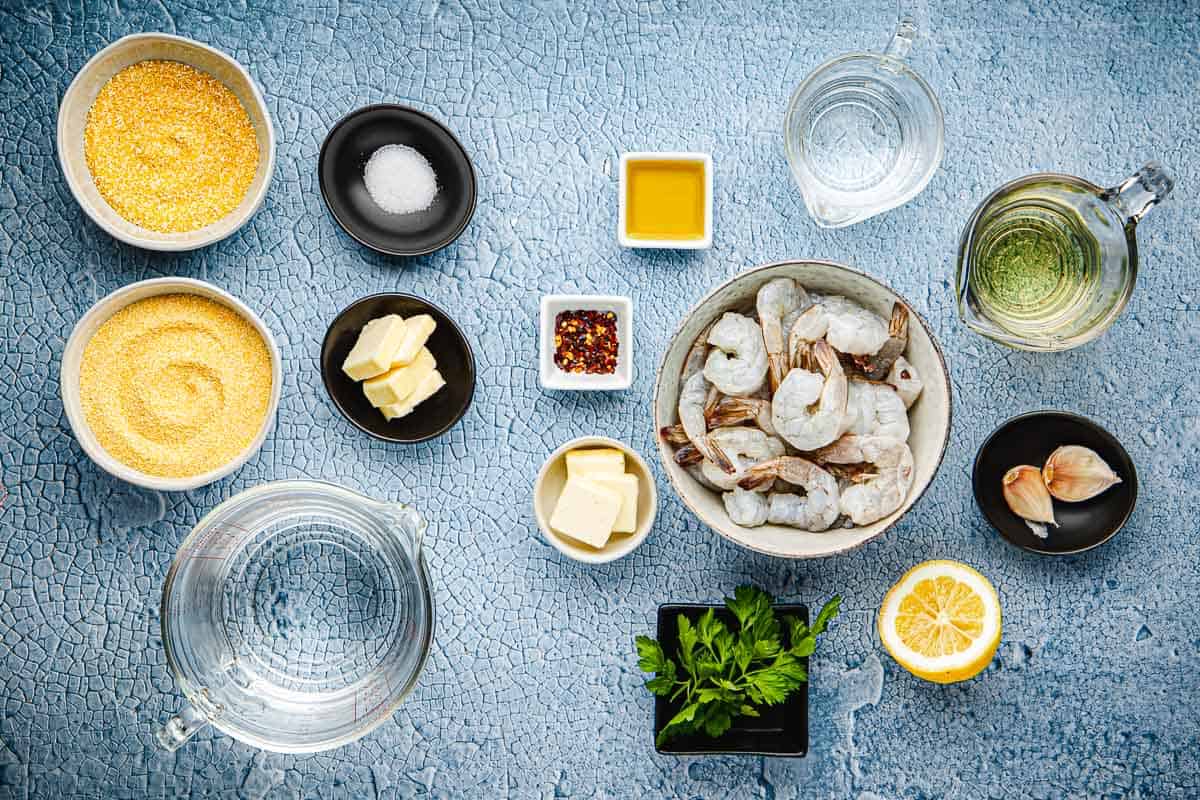 ingredients for polenta and shrimp including fine cornmeal, medium cornmeal, water, salt, butter, olive oil, garlic, red pepper flakes, white wine, shrimp, parsley, and lemon.