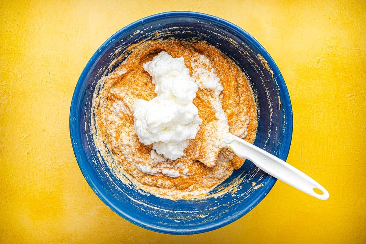 Torta di Carote (Italian Carrot Cake) batter being stirred in a bowl with a spatula.