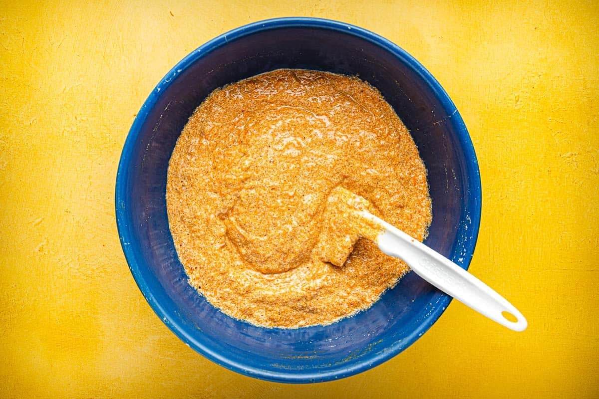 Torta di Carote (Italian Carrot Cake) batter being stirred in a bowl with a spatula.