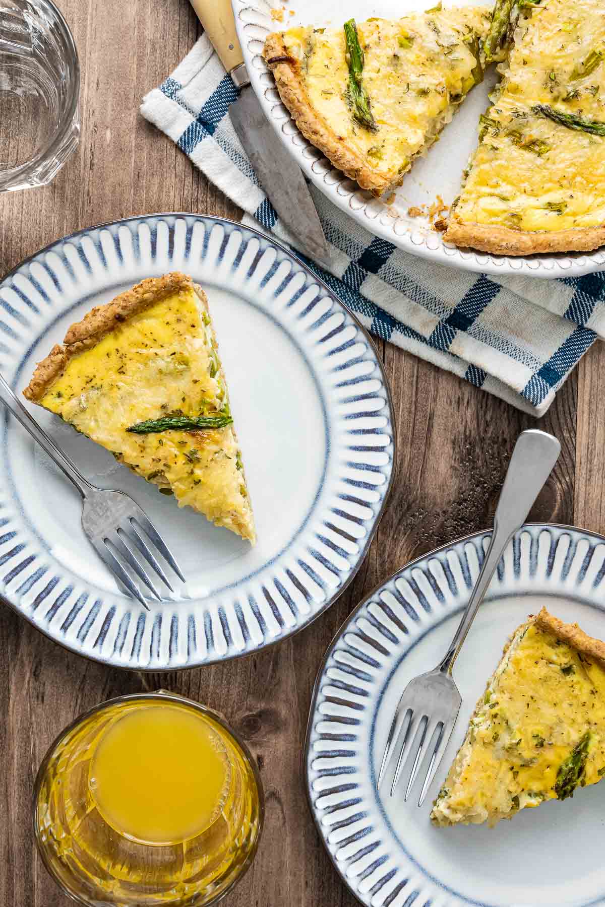 Two blue and white plates with slices of asparagus quiche.