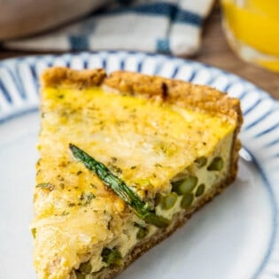 Close up of healthy asparagus quiche with a slice of asparagus on top.