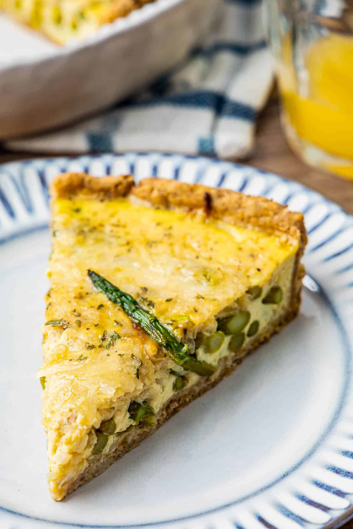 Close up of healthy asparagus quiche with a slice of asparagus on top.