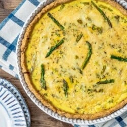 Overhead shot of unsliced asparagus quiche in the tin.