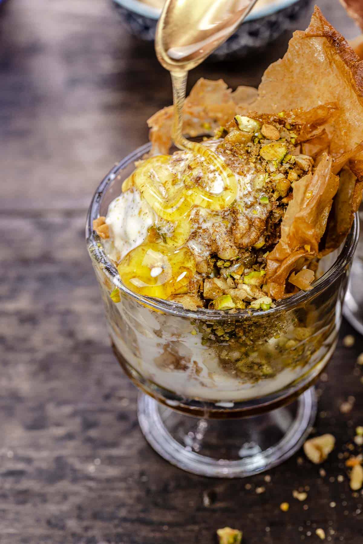 honey being drizzled on a baklava ice cream sundae.