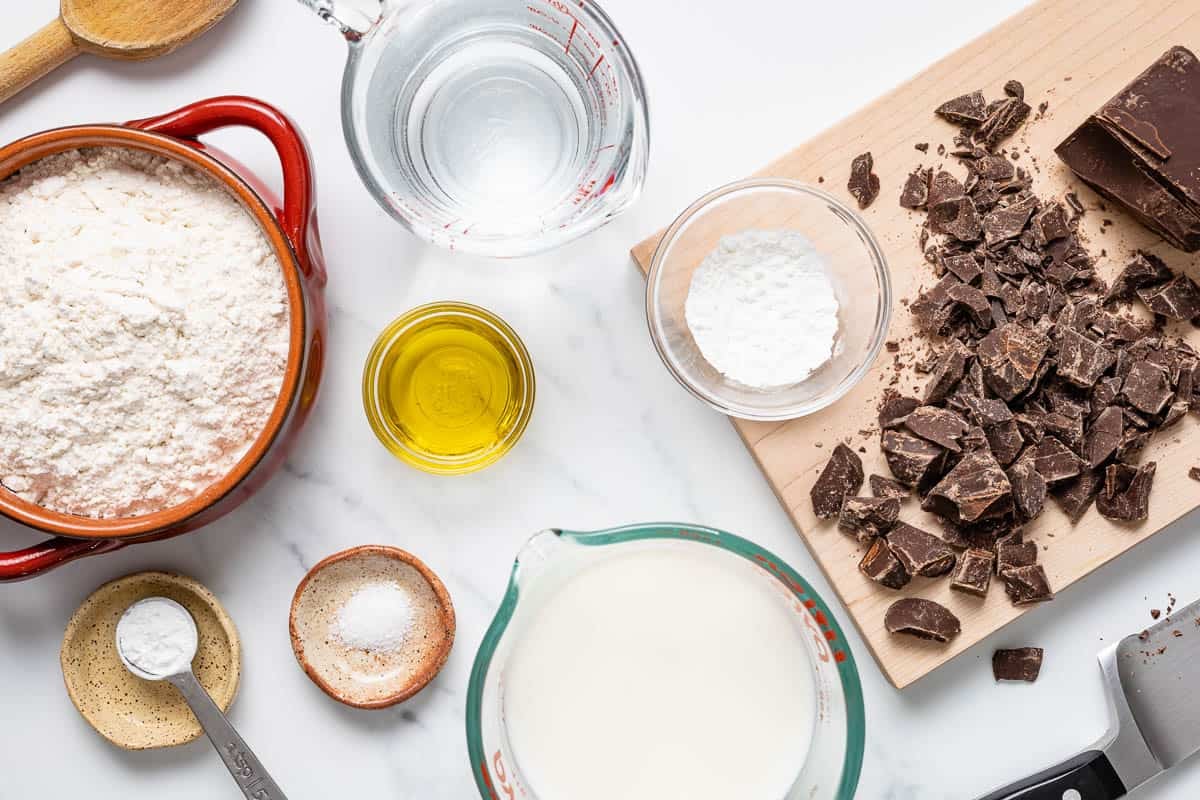 Ingredients for Spanish Churros with drinking chocolate, including flour, baking powder, oil, salt, and chopped chocolate.