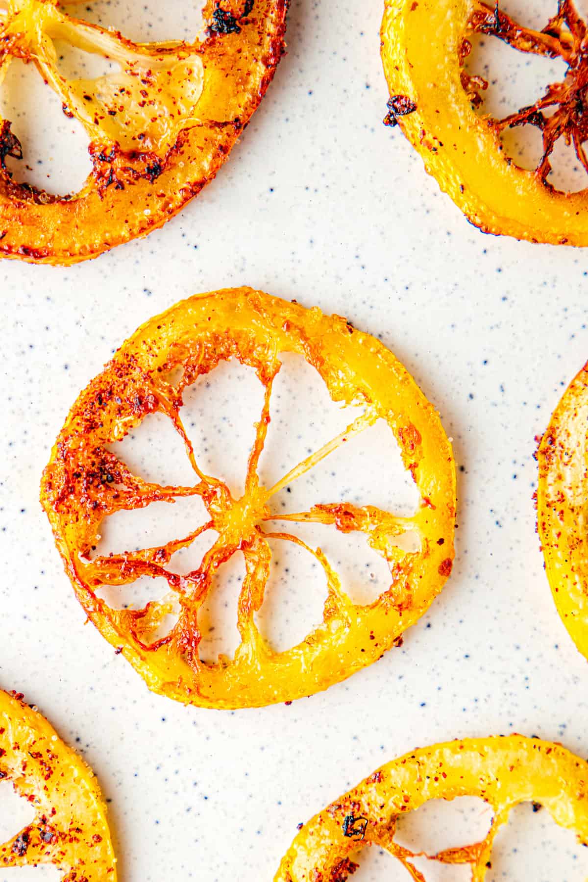 One fried lemon ring with crisp golden brown edges on a white background.