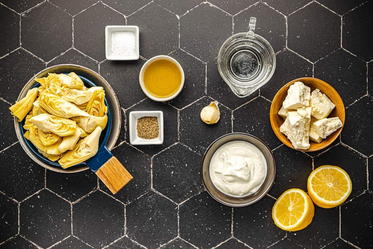 Ingredients for roasted artichoke hearts, including canned artichokes, salt, pepper, oil, feta, lemon, and Greek yogurt.