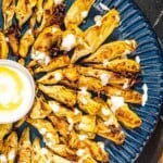 Overhead shot of artichoke hearts with a light drizzle of feta and Greek yogurt dressing.